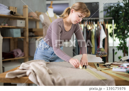 Tailor woman cutting fabric in the workshop 139175976