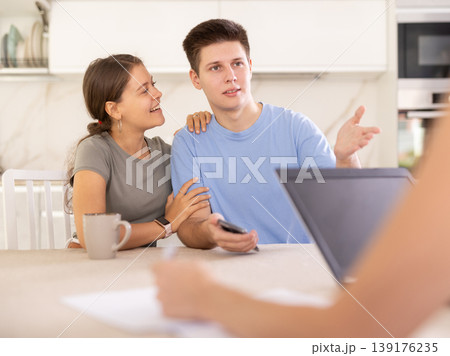 An insurance agent tells young couple the terms of property and life insurance An insurance agent tells young couple the terms of property and life insurance 139176235