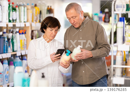 Couple man and woman scanning qr code for liquid soap Couple man and woman scanning qr code for liquid soap 139176285