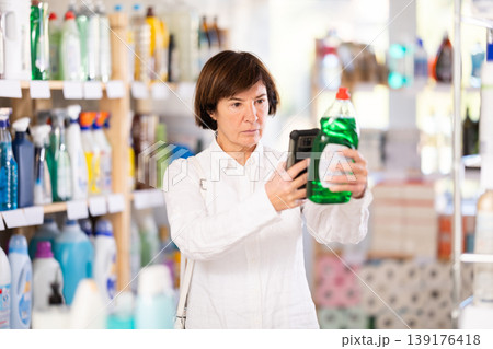 Elderly woman scanning qr code for dishwashing 139176418