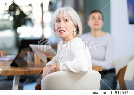 Two female colleagues are watching presentation in office room. Two female colleagues are watching presentation in office room. 139176429
