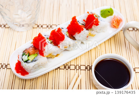 Sushi roll uramaki - tobiko roll with salmon, avocado, pepino, tobiko Sushi roll uramaki - tobiko roll with salmon, avocado, pepino, tobiko 139176435