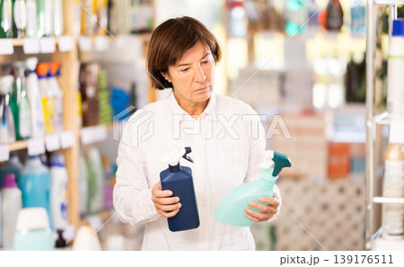 Elderly woman chooses cleaning spray in store 139176511