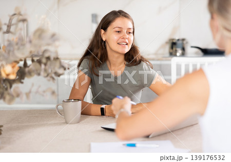 Young girl communicating with partner in the kitchen Young girl communicating with partner in the kitchen 139176532