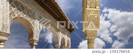 Arches in Islamic (Moorish) style (against the background of a beautiful sky with clouds) in Alhambra, Granada, Spain Arches in Islamic (Moorish) style (against the background of a beautiful sky with clouds) in Alhambra, Granada, Spain 139176658
