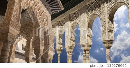 Arches in Islamic (Moorish) style (against the background of a beautiful sky with clouds) in Alhambra, Granada, Spain Arches in Islamic (Moorish) style (against the background of a beautiful sky with clouds) in Alhambra, Granada, Spain 139176662