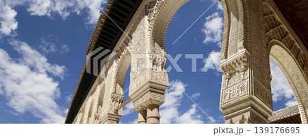 Arches in Islamic (Moorish) style (against the background of a beautiful sky with clouds) in Alhambra, Granada, Spain Arches in Islamic (Moorish) style (against the background of a beautiful sky with clouds) in Alhambra, Granada, Spain 139176695