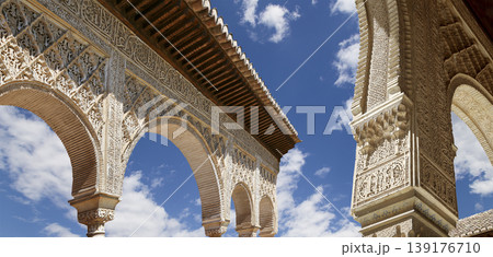Arches in Islamic (Moorish) style (against the background of a beautiful sky with clouds) in Alhambra, Granada, Spain Arches in Islamic (Moorish) style (against the background of a beautiful sky with clouds) in Alhambra, Granada, Spain 139176710