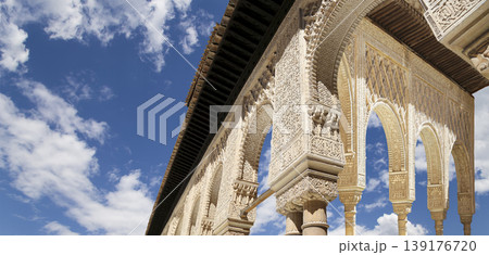 Arches in Islamic (Moorish) style (against the background of a beautiful sky with clouds) in Alhambra, Granada, Spain Arches in Islamic (Moorish) style (against the background of a beautiful sky with clouds) in Alhambra, Granada, Spain 139176720