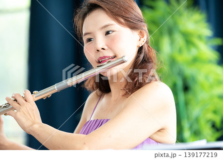 Flute classical instrument profestional player playing song. A young and elegant Asian woman plays the flute. Flute classical instrument profestional player playing song. A young and elegant Asian woman plays the flute. 139177219