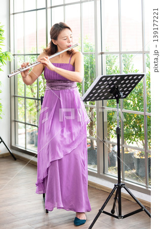 Flute classical instrument profestional player playing song. A young and elegant Asian woman plays the flute. Flute classical instrument profestional player playing song. A young and elegant Asian woman plays the flute. 139177221