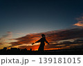 夕暮れの空を背景に嬉しさを表現する女性のシルエット 139181015