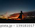 夕焼けの空を見上げる女性 139181017