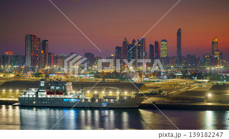 Abu Dhabi, United Arab Emirates - Jan 10 2024, Panoramic view of city with downtown skyscrapers, in foreground a port with a moored cruise ship, yacht, at sunset, Abu Dhabi, United Arab Emirates Abu Dhabi, United Arab Emirates - Jan 10 2024, Panoramic view of city with downtown skyscrapers, in foreground a port with a moored cruise ship, yacht, at sunset, Abu Dhabi, United Arab Emirates 139182247