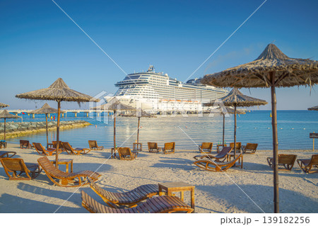Sir Bani Yas island, United Arab Emirates - Jan 11 2024, Panoramic view of the MSC Virtuosa cruise ship in the foreground is a beach with sun loungers, Sir Bani Yas, Abu Dhabi, United Arab Emirates Sir Bani Yas island, United Arab Emirates - Jan 11 2024, Panoramic view of the MSC Virtuosa cruise ship in the foreground is a beach with sun loungers, Sir Bani Yas, Abu Dhabi, United Arab Emirates 139182256