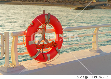 Sir Bani Yas, United Arab Emirates - Jan 11 2024, A lifebuoy hangs on the dock, with the beach in the background, Sir Bani Yas, United Arab Emirates Sir Bani Yas, United Arab Emirates - Jan 11 2024, A lifebuoy hangs on the dock, with the beach in the background, Sir Bani Yas, United Arab Emirates 139182263