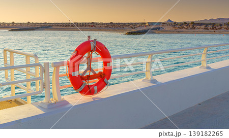 Sir Bani Yas, United Arab Emirates - Jan 11 2024, A lifebuoy hangs on the dock, with the beach in the background, Sir Bani Yas, United Arab Emirates Sir Bani Yas, United Arab Emirates - Jan 11 2024, A lifebuoy hangs on the dock, with the beach in the background, Sir Bani Yas, United Arab Emirates 139182265