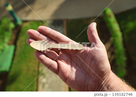 A small eco-friendly wooden spoon in a person's hand A small eco-friendly wooden spoon in a person's hand 139182746