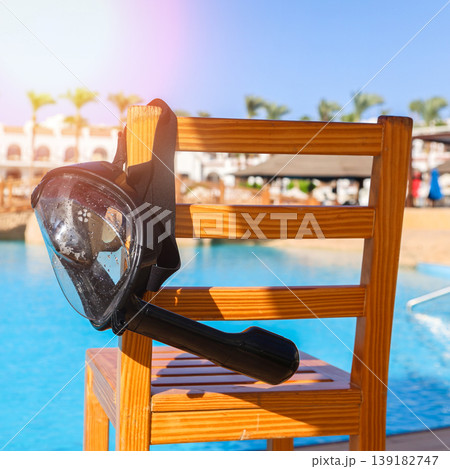 A black mask with a snorkel for scuba diving hangs on a lifeguard chair A black mask with a snorkel for scuba diving hangs on a lifeguard chair 139182747