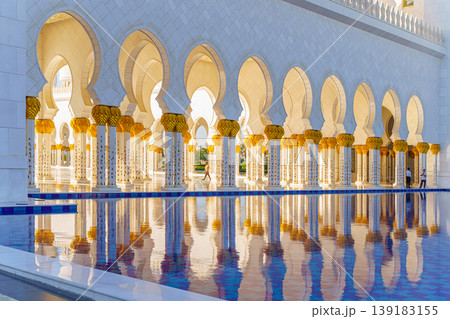 Abu Dhabi, United Arab Emirates - Jan 10 2024, panoramic view of Sheikh Zayed Grand Mosque colonnade with arches and pool on foreground, at daytime, Abu Dhabi, United Arab Emirates 139183155