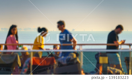 Manama, Bahrain- Jan 09 2024, Panoramic view of people walking on the upper deck of the MSC Virtuosa cruise ship, in the background the sea with oil rigs, at sunset Manama, Bahrain Manama, Bahrain- Jan 09 2024, Panoramic view of people walking on the upper deck of the MSC Virtuosa cruise ship, in the background the sea with oil rigs, at sunset Manama, Bahrain 139183223