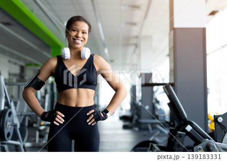 Confident smiling young Black woman standing in gym with hands on hips 139183331
