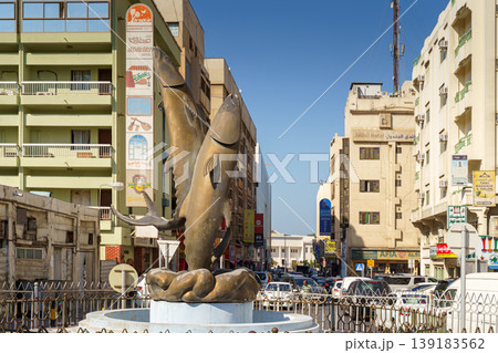 Manama, Bahrain - Jan 08 2024, Panoramic view of the wide market street, with a fountain with bronze fish sculptures, is a busy parking lot around, in the daytime, Manama, Bahrain Manama, Bahrain - Jan 08 2024, Panoramic view of the wide market street, with a fountain with bronze fish sculptures, is a busy parking lot around, in the daytime, Manama, Bahrain 139183562