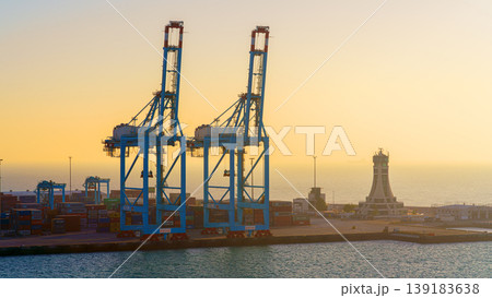 Manama, Bahrain - Jan 08 2024, Panoramic view of Bahrain commercial port with blue cranes, buildings and containers, with sea on foreground, by the morning, dawn, sunrise, Manama, Bahrain Manama, Bahrain - Jan 08 2024, Panoramic view of Bahrain commercial port with blue cranes, buildings and containers, with sea on foreground, by the morning, dawn, sunrise, Manama, Bahrain 139183638