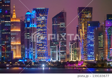Doha, Qatar - Jan 07 2024, Panorama of the skyscrapers of Doha downtown business centers, with illumination and street lights on, at nighttime Doha, Qatar  139183677