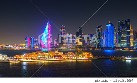 Doha, Qatar - Jan 07 2024, a panoramic view of Doha, Mina district Doha port in the foreground, skyscrapers and Al Mana tower in the background, with illumination, at nighttime, Doha, Qatar Doha, Qatar - Jan 07 2024, a panoramic view of Doha, Mina district Doha port in the foreground, skyscrapers and Al Mana tower in the background, with illumination, at nighttime, Doha, Qatar 139183684