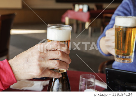 生ビールで乾杯する手のアップ 生ビールで乾杯する手のアップ 139184124