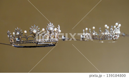 Doha, Qatar - Jan 06 2024, a close up view of historical vintage royal jewellery, the two crowns, exhibits of National Museum of Qatar, on monochrome background, under the glass, Doha, Qatar Doha, Qatar - Jan 06 2024, a close up view of historical vintage royal jewellery, the two crowns, exhibits of National Museum of Qatar, on monochrome background, under the glass, Doha, Qatar 139184800