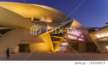 Doha, Qatar - Jan 06 2024, a bottom up view of National Museum of Qatar part of facade, exterior, in courtyard, patio shaped like a desert rose, at nighttime, with illumination, Doha, Qatar  139184815