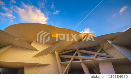 Doha, Qatar - Jan 06 2024, a panoramic view of National Museum of Qatar facade, exterior, shaped like a desert rose, at evening with blue sky, Doha, Qatar  139184920