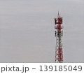 Sturdy Red and Silver Telecommunication Tower Amidst a Hazy Sky A Commercially Applicable Image 139185049
