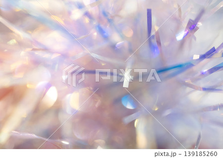Colorful strands of shiny tinsel in various hues create a festive background with soft bokeh effects, ideal for holiday and celebration themes Colorful strands of shiny tinsel in various hues create a festive background with soft bokeh effects, ideal for holiday and celebration themes 139185260