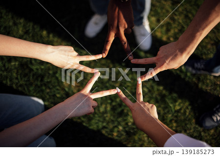 Diverse group of hands forming peace signs on green grass, showcasing unity and friendship in an outdoor setting with sunlight illuminating the scene Diverse group of hands forming peace signs on green grass, showcasing unity and friendship in an outdoor setting with sunlight illuminating the scene 139185273
