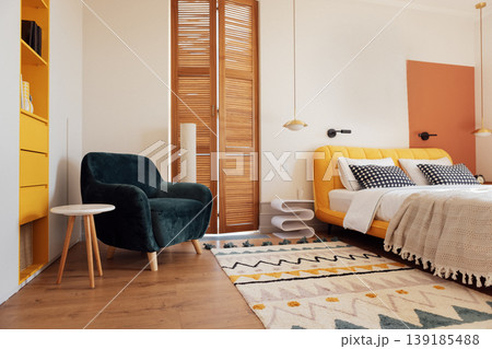 A modern bedroom with a comfortable bed and a bright yellow headboard A modern bedroom with a comfortable bed and a bright yellow headboard 139185488