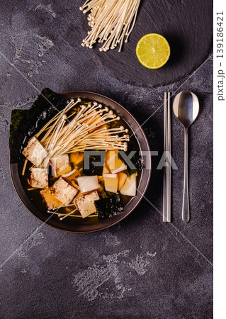 Asian-style soup with squid, tofu and enoki mushrooms. Asian-style soup with squid, tofu and enoki mushrooms. 139186421