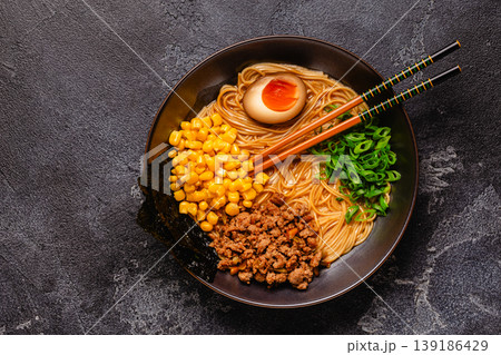 A bowl of ramen with noodles, meat and green onions. 139186429