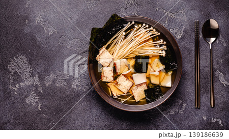 Asian-style soup with squid, tofu and enoki mushrooms. Asian-style soup with squid, tofu and enoki mushrooms. 139186639