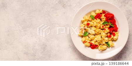 pasta in a plate with tomato sauce. 139186644