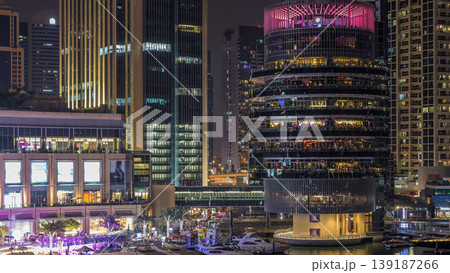 Aerial view of Dubai Marina with shopping mall, restaurants, towers and yachts night timelapse, United Arab Emirates. Aerial view of Dubai Marina with shopping mall, restaurants, towers and yachts night timelapse, United Arab Emirates. 139187266