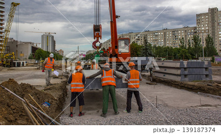 Installing concrete plates by crane at road construction site timelapse. Installing concrete plates by crane at road construction site timelapse. 139187374