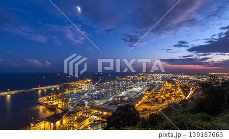Seaport and loading docks at the port with cranes and multi-colored cargo containers day to night timelapse Seaport and loading docks at the port with cranes and multi-colored cargo containers day to night timelapse 139187663