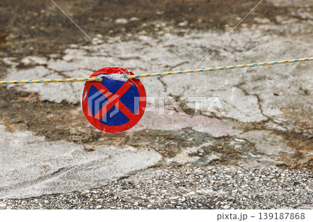 Closeup of a red blue no stopping traffic sign blocking walkway. Urban restriction and traffic regulation concept with copy space. Closeup of a red blue no stopping traffic sign blocking walkway. Urban restriction and traffic regulation concept with copy space. 139187868