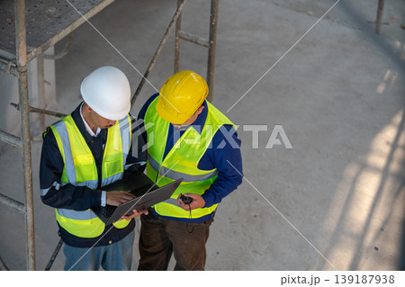 Construction workers collaborating on project construction site photo indoor overhead view teamwork and safety Construction workers collaborating on project construction site photo indoor overhead view teamwork and safety 139187938
