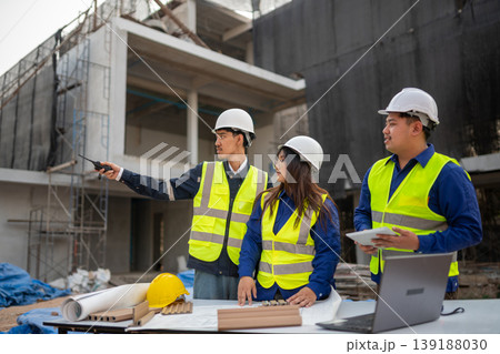 Construction team collaborating on project plans at urban building site professional environment overhead view teamwork concept Construction team collaborating on project plans at urban building site professional environment overhead view teamwork concept 139188030