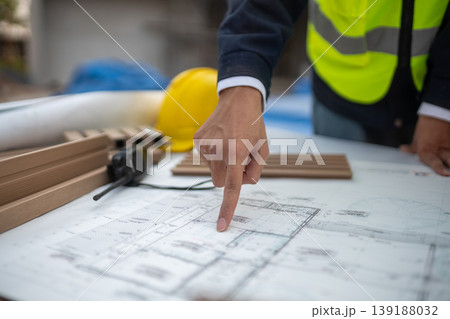 Construction planning action job site blueprint review professional environment close-up view project organization for success Construction planning action job site blueprint review professional environment close-up view project organization for success 139188032