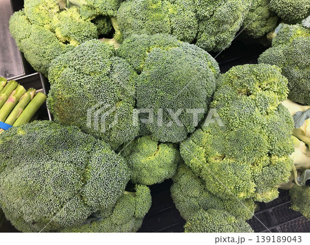 Fresh green broccoli heads display at grocery store produce section 139189043